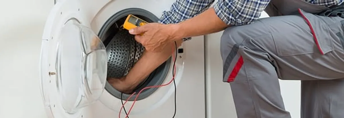 Dryer repair technician inspecting and repairing a clothes dryer in Hialeah, FL