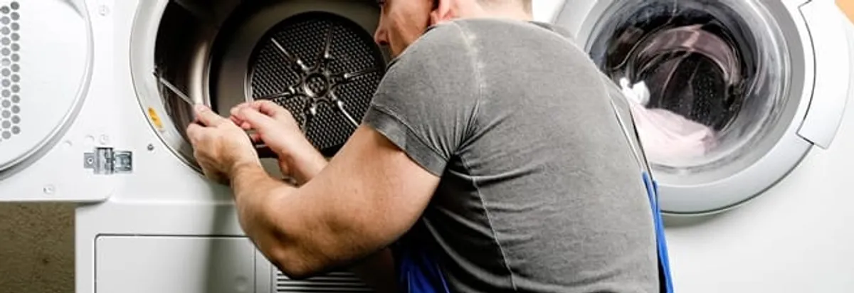 Dryer repair technician fixing a clothes dryer drum in Hialeah, FL