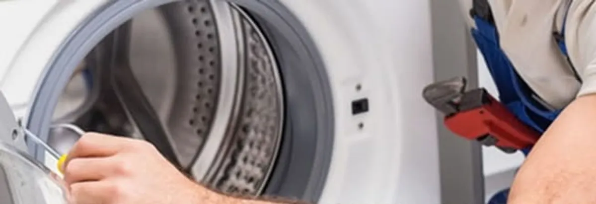 Appliance technician repairing a clothes dryer drum and internal parts in Hialeah, FL