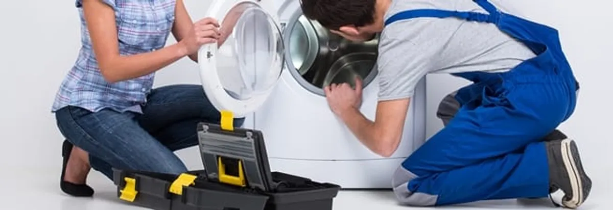 Washer repair technician inspecting a front-load washing machine with tools in Hialeah, FL