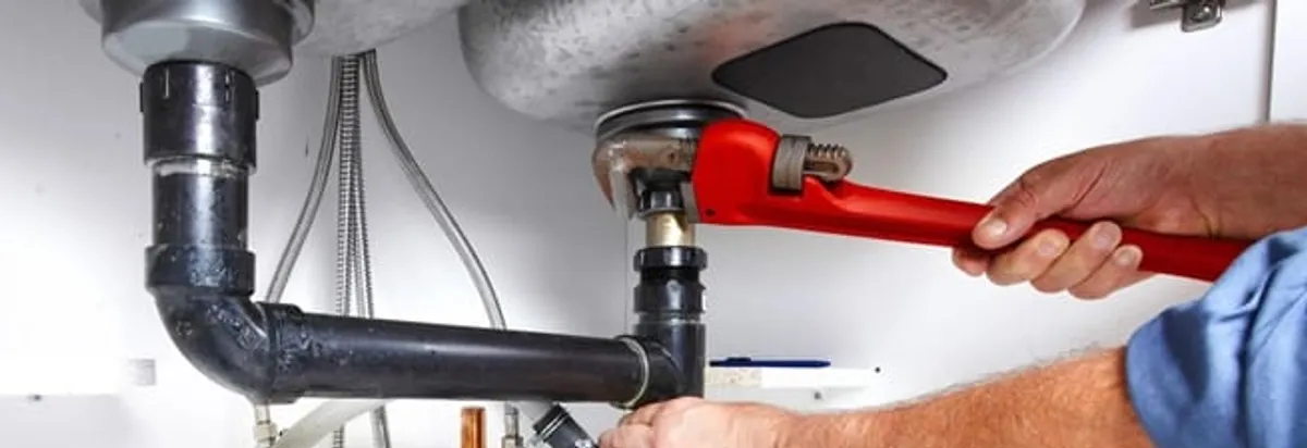 Garbage disposal repair technician tightening the sink drain and disposal connection in Hialeah, FL