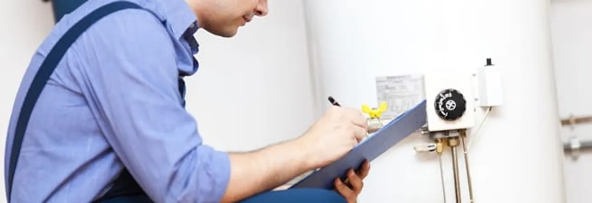 Water heater repair technician inspecting the unit and recording service notes in Hialeah, FL